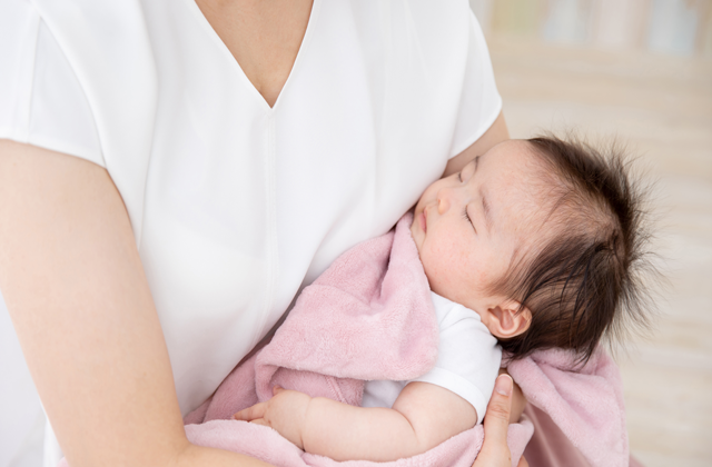 お母さんに抱かれてすこやかに睡る赤ちゃん