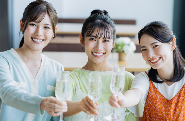 ワイングラスをかかげ女子会を開くお肌ピチピチのワークウーマン３人