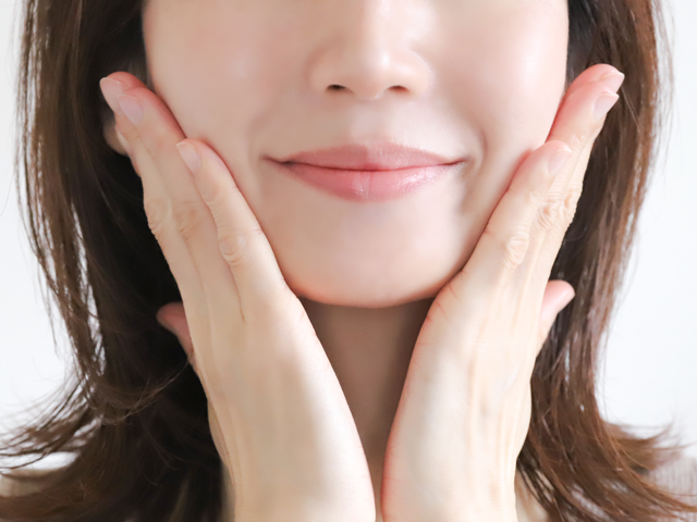 肌の綺麗な女性が両手で顔を挟んでいる画像